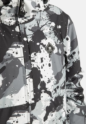 Schwarze, weiße und graue Jacke mit Klecksmuster,Frontreißverschluss, verstellbarem Kapuze und einem rautenförmigen Logo auf der Brust.