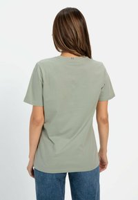 Lichtgroene katoenen t-shirt met een ronde hals, korte mouwen en een subtiele accentdetail op de achterkant onder de halslijn.