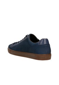 Námořnické modré semišové tenisky s hladkým koženým akcentem na patě a hnědou gumovou podrážkou. Obsahují sedm očíček a minimalistický design.