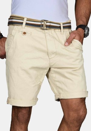 Beige Baumwollshorts mit aufgerollten Säumen, Vordertaschen, Knopfverschluss und einem mehrfarbigen gewebten Gürtel mit Metallschnalle.