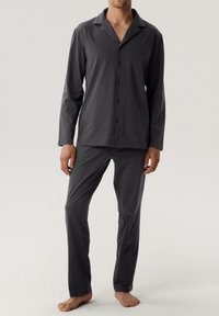 Wielokolorowy, szary, dwuczęściowy zestaw piżamowy wykonany z miękkiego materiału, zawierający koszulę z długim rękawem na guziki i luźne spodnie.