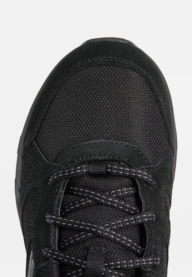 Zwarte sportieve schoen met een combinatie van mesh en suède materialen, ronde neus, gestructureerd oppervlak en contrasterende stiksels op de veters.