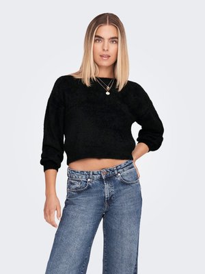 Sweater cropped preto em tecido suave e texturizado, combinado com jeans de denim azul desbotado de cintura alta, com fecho de botão e bolsos laterais.