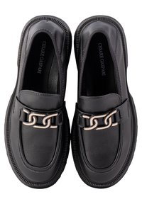 Mocassins en cuir noir à finition texturée, ornés d'un accent chaîne métallique à l'avant et dotés d'une semelle en caoutchouc résistante.