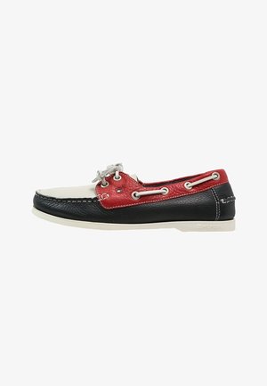 Chaussure bateau en cuir pour homme en noir, blanc et rouge avec des lacets blancs et des détails de marque sur la semelle et le panneau latéral.