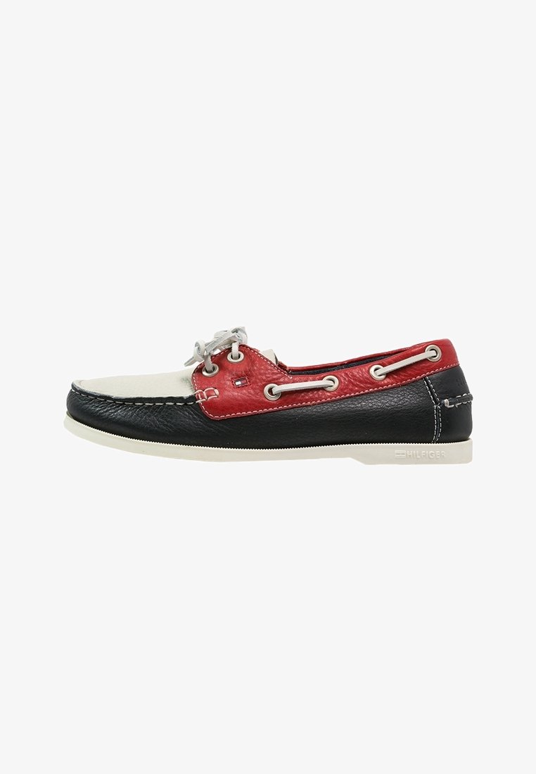 Chaussure bateau en cuir pour homme en noir, blanc et rouge avec des lacets blancs et des détails de marque sur la semelle et le panneau latéral.
