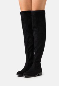 Over-the-knee black suede boots with a flat sole, smooth texture, and simple design, featuring a side zip detail for easy wear.