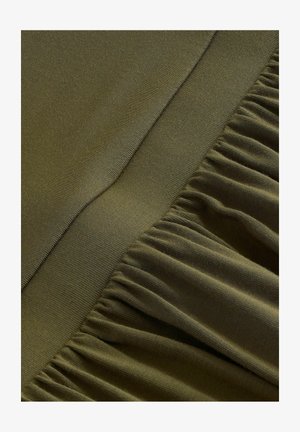 Olivgrüner Stoff mit einer glatten Oberfläche, der an einer Kante mit gerafften Volants und auf dem flachen Bereich mit einer ordentlichen Naht versehen ist.