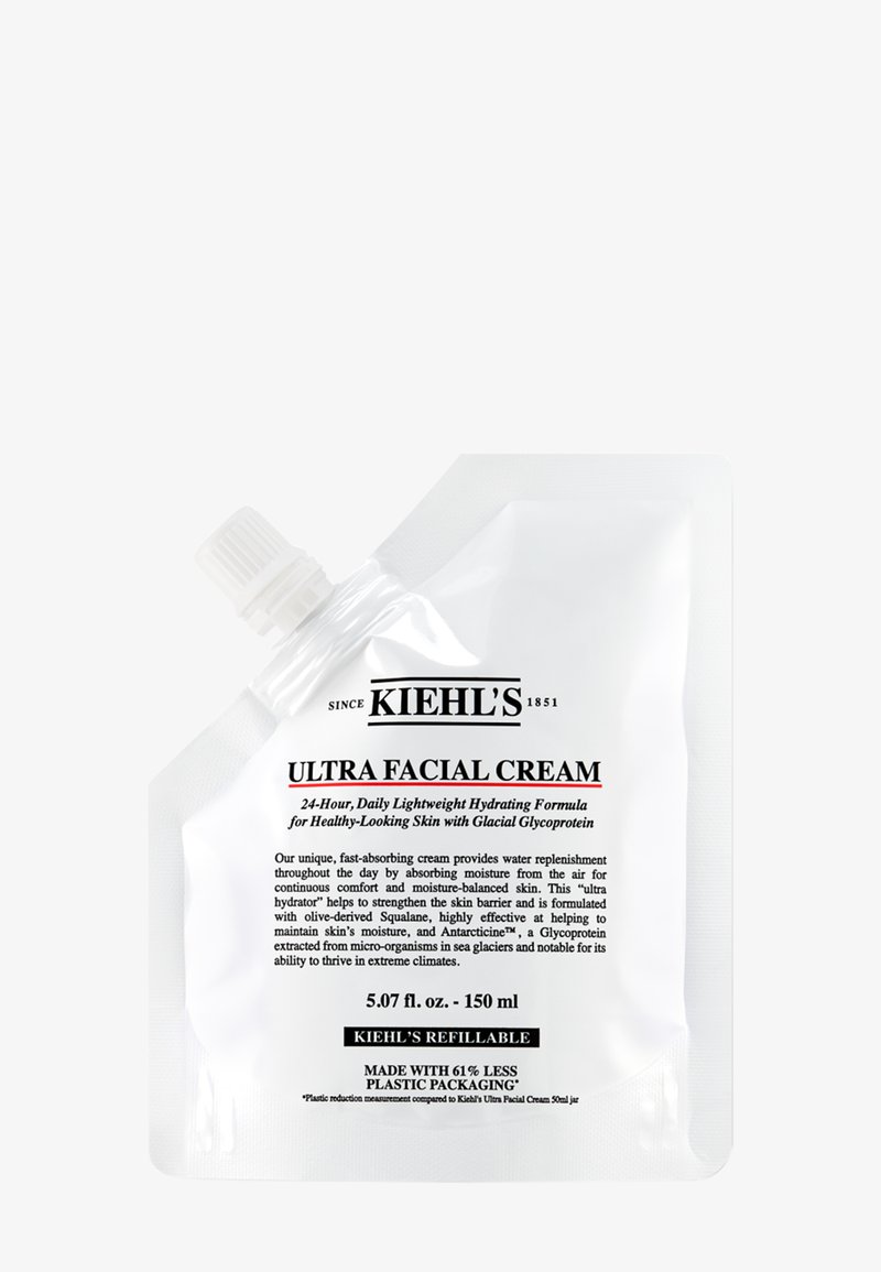 Pochette blanche contenant la Crème Ultra Facial de Kiehl's avec un bouchon à vis. Le texte sur l'étiquette inclut le nom du produit, des détails d'utilisation et des notes sur la durabilité.