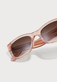 Rose-tinted sunglasses with a chunky plastic frame, featuring a glittery texture, brown lenses, and straight temple arms.