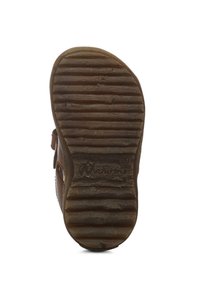 Podeszwa brązowego skórzanego buta z wyraźnymi, poziomymi i pionowymi rowkami, z zaokrąglonym noskiem i ozdobnym paskiem po boku. Widoczne logo marki.