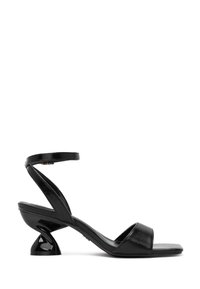 Mustat korkokengät avonaisella varvalla, joissa on kiiltävä pinta, hoikka nilkkahihna ja ainutlaatuinen kaareva korko.