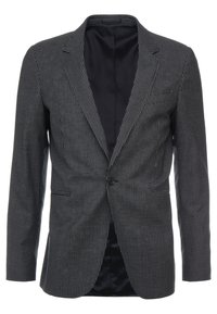 Czarny i biały żakiet w wzór houndstooth z klapami, pojedynczym zapięciem na guzik i dwoma przednimi kieszeniami. Gładka czarna podszewka wewnątrz.