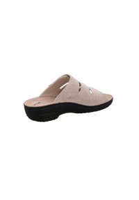 Beige slipper sandaal met een gestructureerd oppervlak, voorzien van uitsnijdingen en een zwarte rubberen zool, die zorgt voor een comfortabele pasvorm.