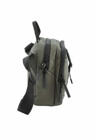 Bolso de nailon verde oliva con múltiples compartimentos, cuenta con cremalleras y correas negras. Textura suave y diseño compacto con una asa en la parte superior.