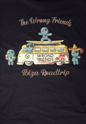 T-shirt nera con una grafica colorata di un furgone retro accompagnato da quattro personaggi in stile cartone animato. Il testo recita "Gli Amici Sbagliati" e "Roadtrip a Ibiza."
