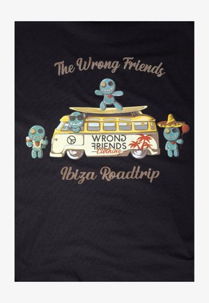 T-shirt nera con una grafica colorata di un furgone retro accompagnato da quattro personaggi in stile cartone animato. Il testo recita "Gli Amici Sbagliati" e "Roadtrip a Ibiza."