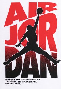 Bílá tričko s černou siluetou basketbalisty ve skoku, s tučným červeným textem „AIR JORDAN“ a gradientním efektem.