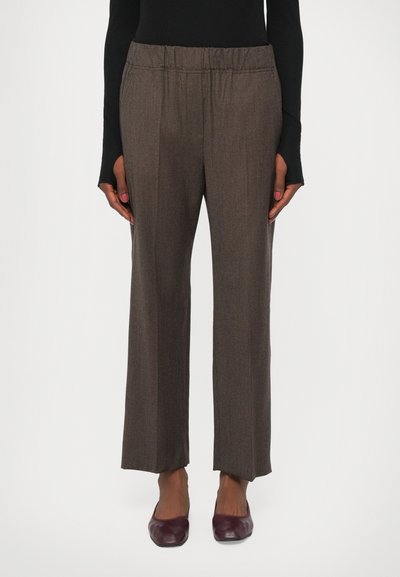 Pantalons à carreaux marron avec une ceinture élastique, coupe large, texture douce et coupe droite, associés à des ballerines bordeaux foncé.