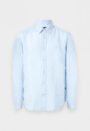 Gaiši zila, garām piedurknēm ar pogām, ar smailu apkakli, izgatavota no viegli teksturēta auduma.