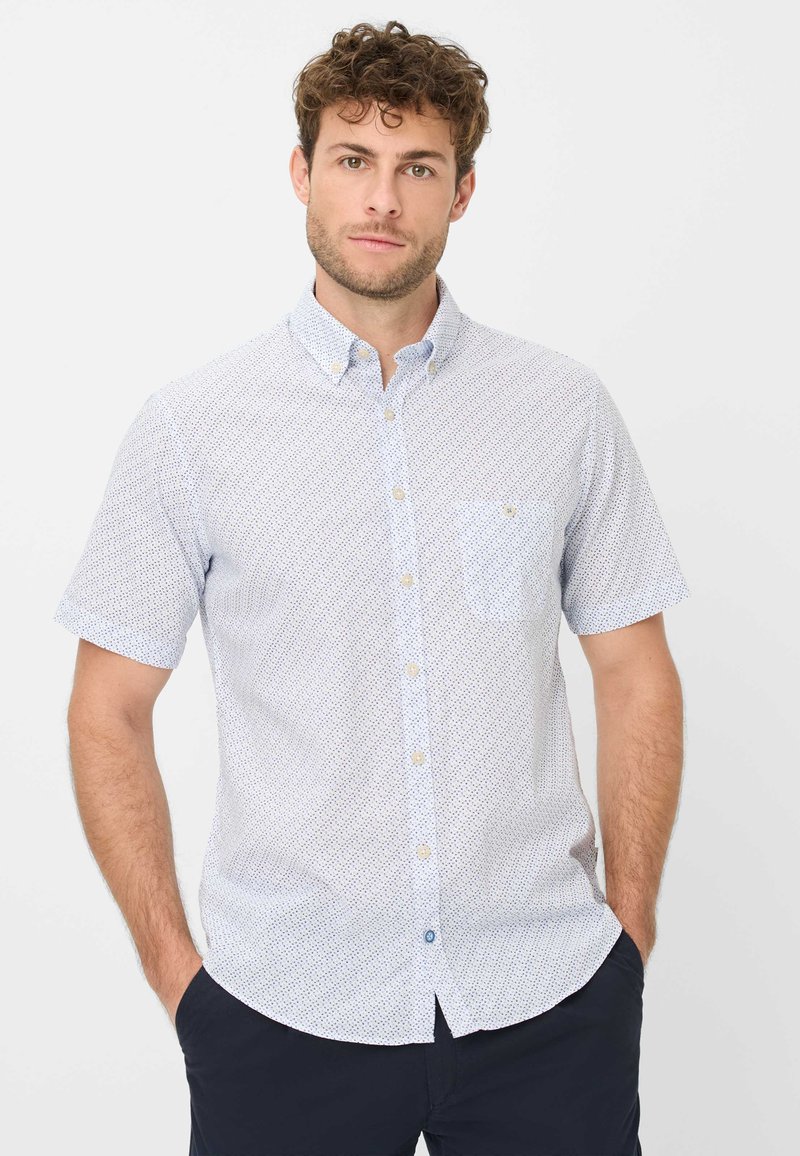 Camicia a maniche corte con bottoni di colore azzurro chiaro, con un motivo sottile, dotata di una tasca sul petto e dettagli dei bottoni a contrasto. Realizzata in misto cotone.