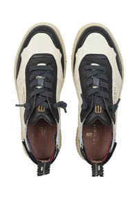 Le calzature presentano una combinazione di pelle crema e nera con accenti testurizzati, punta rotonda e lacci a contrasto. Marchio distintivo sul lato.