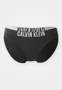 Mustad mustriga naiste aluspüksid, millel on lai valge elastne vöökoht, kus on trükitud "CALVIN KLEIN".