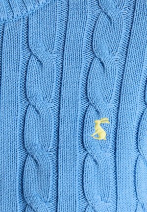 Sinine kootud materjal vertikaalse kava mustriga ja väikese kollase tikitud jänku detailiga ühel kava triibul.