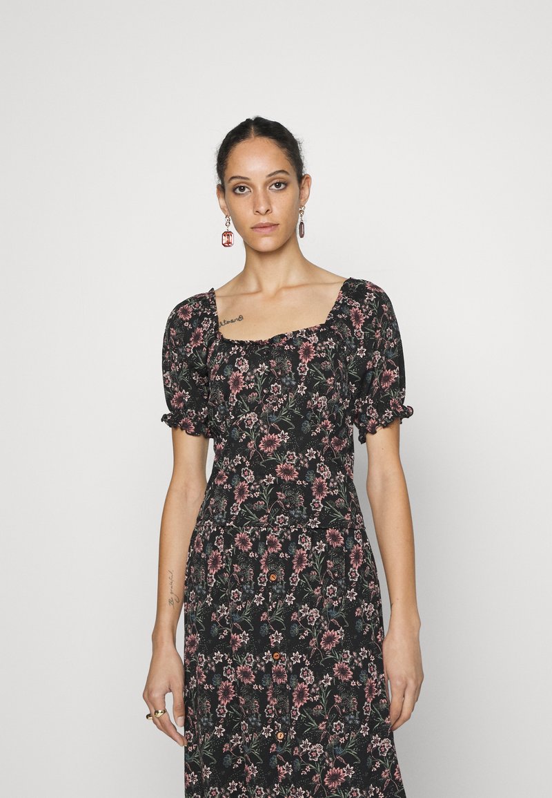 Vestido preto florido com mangas bufantes, decote quadrado e padrões florais rosas. Apresenta um corpete justo e botões ao longo da saia.