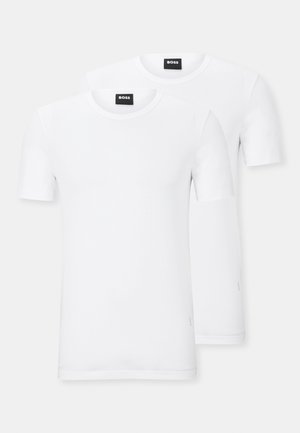 T-shirts blancs en coton doux, avec des manches courtes, un col rond, et un design minimaliste avec une étiquette au col, deux shirts présentés.