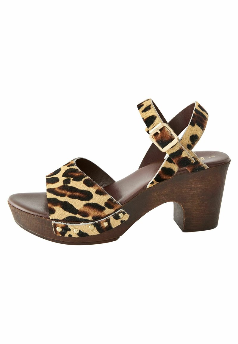 Leopard print platform sandal with a wooden block heel, adjustable ankle strap, and gold stud accents on the band. Soft fabric texture.