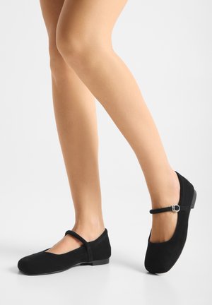 Schwarze Ballerinas aus Wildleder mit abgerundetem Zehenbereich und einem Riemen über dem Spann. Niedriger Blockabsatz mit Gummisohle. Glatte Textur.