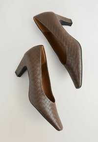 Brown, woven-patterned high heel shoes with a pointed toe and a chunky black heel, featuring a smooth inner lining.
