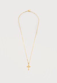 Χρυσό κολιέ με αλυσίδα και μικρό γυαλιστερό σταυρό ως μενταγιόν σε απλό φωτεινό φόντο.