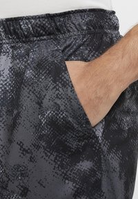 Vyrų �šortai su tamsiai pilku ir juodu abstrakčiu raštu, elastiniu juosmeniu ir šonine kišene. Pagaminti iš lengvos, tekstūruotos medžiagos.