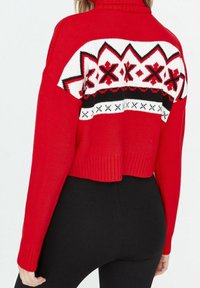 Rode gebreide trui met een cropped ontwerp, met een geometrisch patroon in wit, zwart en rood op de rug. Geribbelde manchetten en zoom.