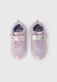 Chaussures de sport pour enfants violettes avec un matériau étincelant, un col rembourré et une bride à scratch ornée d'un motif "Licorne". Semelle transparente.