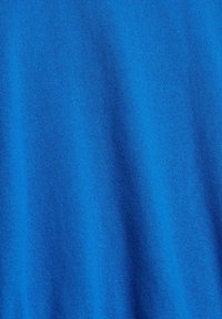 Tissu bleu vif avec une texture tricotée fine et des plis verticaux subtils créant des ombres douces.