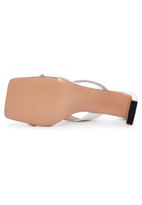 Sandal con tacco alto bianco caratterizzato da una punta quadrata elegante, suola nudo liscia e una sottile cinghia scintillante alla caviglia. Tacco testurizzato per una migliore aderenza.