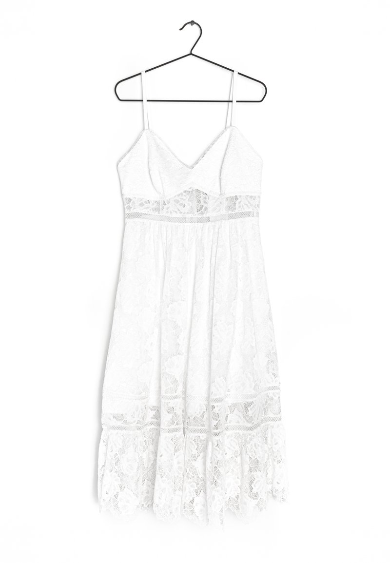 Vestido blanco de encaje con tirantes finos, escote en V, corsé ajustado y falda en capas con motivos florales y acentos de encaje.