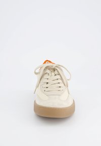 Sneaker beige chiaro con dettagli in suede testurizzato e pelle liscia. Presenta lacci tondi e una suola in gomma. Dettaglio sul tallone di un vivace arancione.