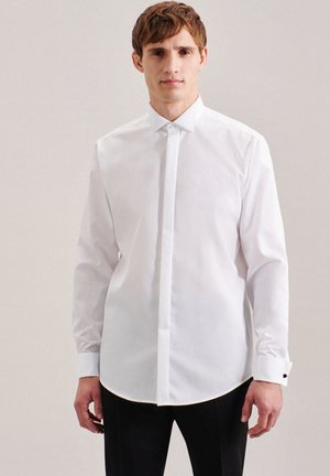 Camicia bianca a maniche lunghe con bottoni realizzata in tessuto liscio, dotata di colletto strutturato, pattina discreta e dettagli a contrasto sui polsini.