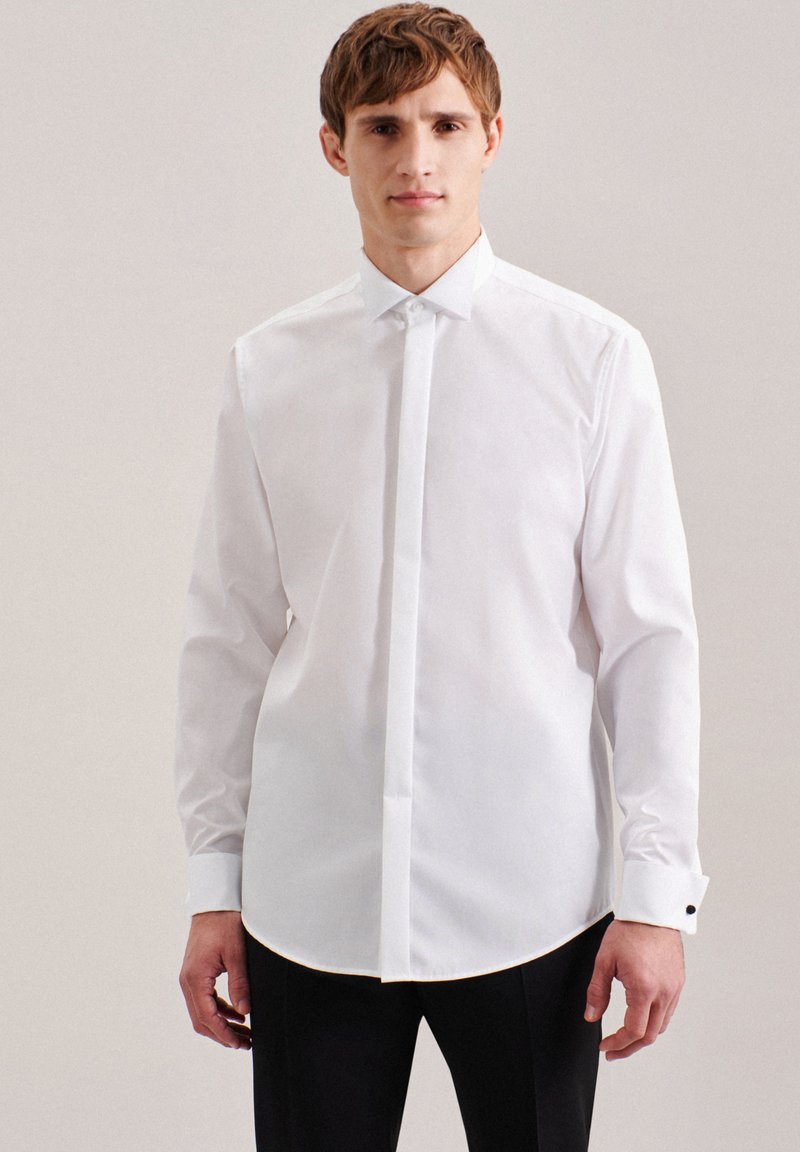 Camicia bianca a maniche lunghe con bottoni realizzata in tessuto liscio, dotata di colletto strutturato, pattina discreta e dettagli a contrasto sui polsini.