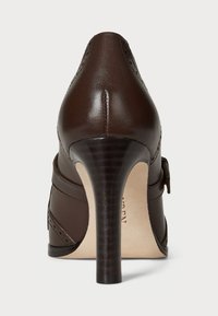 Brown leather high-heeled shoe with a tapered heel, decorative stitching, and a side buckle detail. Smooth finish and rounded toe design.