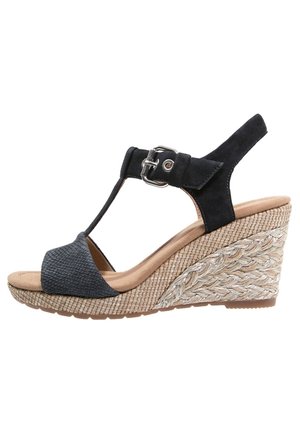 Sort kilehæle sandal med T-strop design, struktureret overdel og en vævet rebhælhøjden. Indeholder en justerbar spænde og en polstret sål.