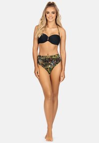 Czarny bikini górny z ozdobnym skrętem i złotymi pierścieniami, w zestawie z wysokim dołem w intensywny zwierzęcy wzór w kolorze żółtym, zielonym i czarnym.