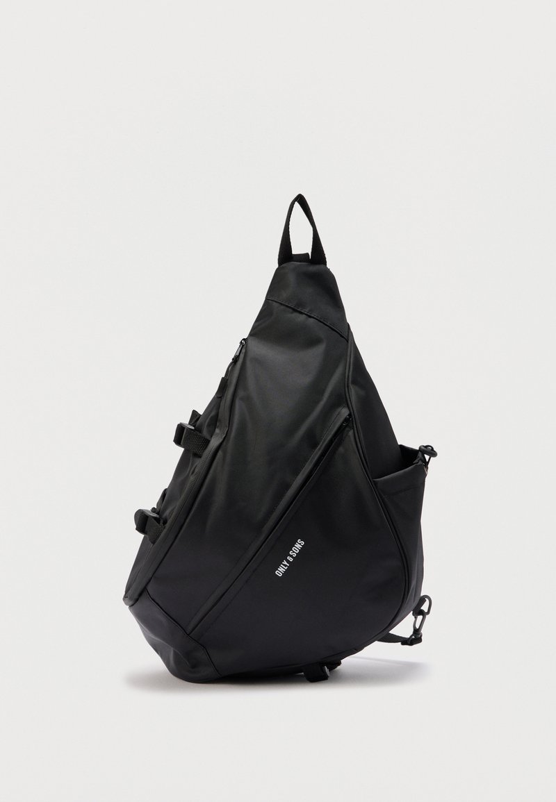 Sac à dos bandoulière triangulaire noir avec fermetures éclair, poches latérales, bretelles réglables et logo "ONLY & SONS" sur la poche avant.
