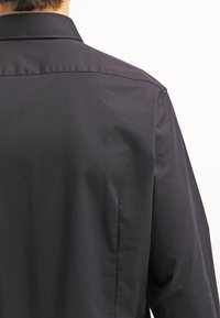 Zwarte button-up overhemd met een soepel oppervlak, klassieke kraag en netjes gestikte achternaden met een relaxed fit.