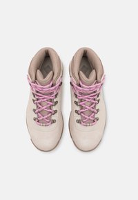 Bottes de randonnée beiges avec des lacets roses, dessus en suède et en mesh, œillets en métal, col rembourré et semelle en caoutchouc texturé.