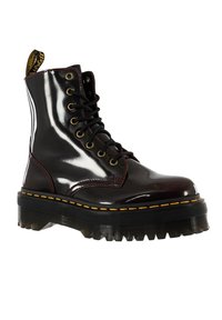 Svarta lackläder ankle boots med gula sömmar, rund tå, snörning framtill och en kraftig svart sula. Har en ögla bak.